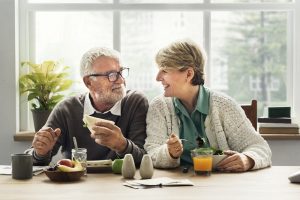 Image of a senior couple having lunch at home, saving on dining expenses through their austerity plan