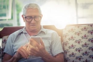 Image of a senior man practicing intraday trading on his phone