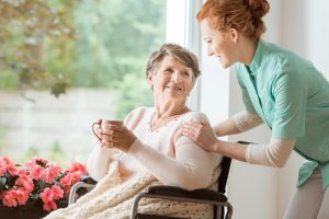 Image of a senior woman receiving help in a nursing home