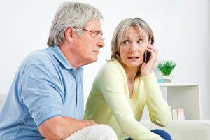 Image of a frustrated senior couple speaking with their financial advisor on the phone