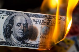 Image of burning money, representing the risk posed by inflation in retirement