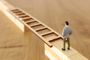 Image of a male figure crossing a gap on a ladder