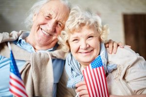 Image of a senior couple holding American flags