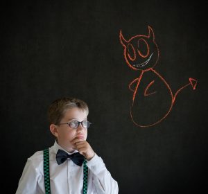 Image of a boy dressed as a businessman making a moral decision.