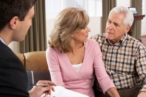 Image of a senior couple discussing finances with an advisor