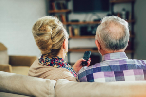 Image of a senior couple watching television using streaming services