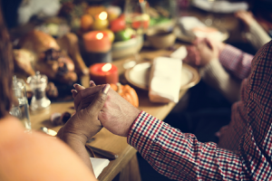 Image of a family giving thanks before their Thanksgiving dinner