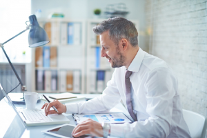 Image of a businessman trading and investing on his laptop