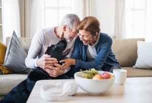 Image of a senior couple laughing with their pet