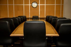 Image of a chair at the head of the table in a conference room