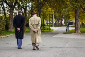 Image of two senior men walking outside of a church