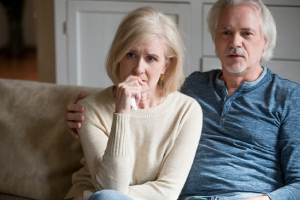 Image of a concerned senior couple watching the news