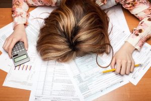 image of a woman exhausted from working on her taxes