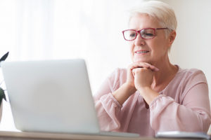 Image of a senior woman researching exchange-traded funds (ETFs) using her laptop