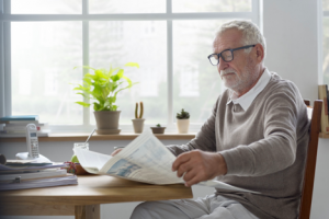 Image of a senior man reading the newspaper