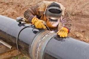 Image of a worker repairing a pipeline