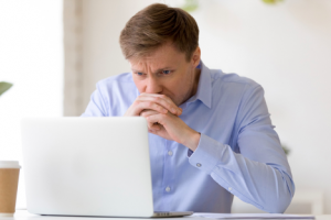 Image of a nervous investor watching his penny stocks on his laptop