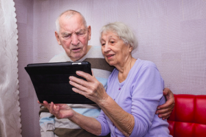 Image of two surprised seniors reading on a tablet