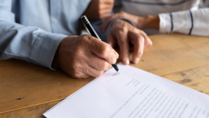 Image of a senior signing on a reverse mortgage