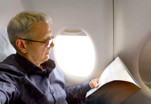 Image of a senior reading on a plane