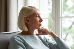 Image of a thoughtful senior woman looking out a window