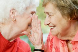 Image of a senior woman sharing a secret with a friend