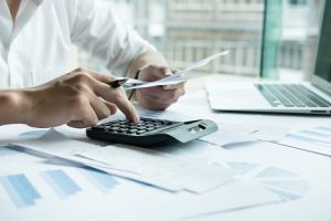 Image of a man using a calculator in his office