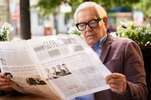 Image of a senior man reading the newspaper