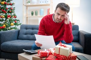 Image of a man looking worried near a Christmas tree