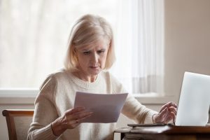 Image of a frustrated senior woman reading