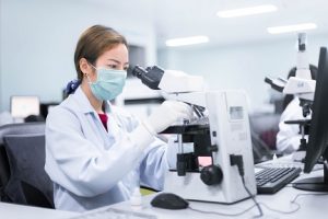 Image of a lab technician using a microscope