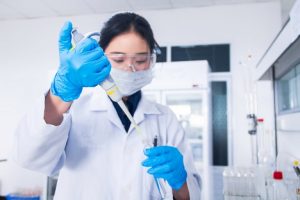 Image of a scientist using a pipette and test tubes