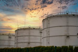 Image of industrial oil tanks at sunset