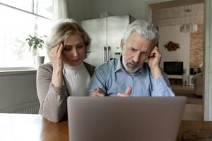 Image of a concerned senior couple looking at their laptop