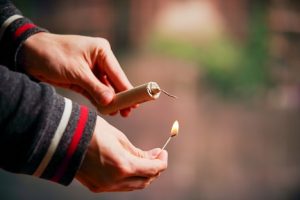 Image of a man lighting a firecracker