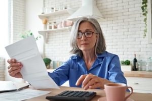 Image of a senior woman managing her finances with a calculator