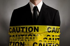 Image of a businessman wrapped in caution tape