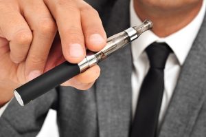 Image of a man vaping in a suit, reflecting Big Tobacco going smokeless