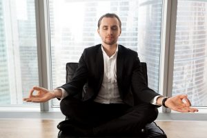 Business man in yogic mediation symbolizing investor discipline