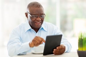 Image of a senior man reading on his tablet