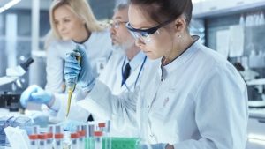 Image of a scientist using micropipette for filling test tubes