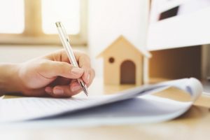 Image of somebody signing a home loan document