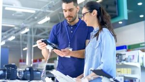 Image of an electronics store consultant helping a customer