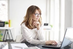 Image of a businesswoman looking at stocks on the computer