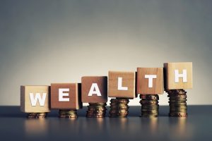 Image of “Wealth” written on stacked wooden blocks