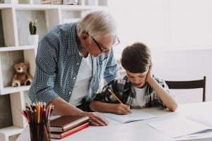 Image of a grandpa helping his grandson do homework