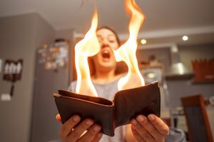 Woman holding a burning wallet