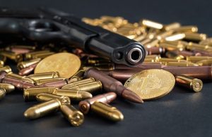 Image of a pistol lying among bullets and Bitcoins