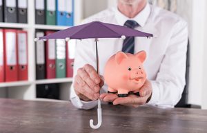 Image of an umbrella held over a piggy bank