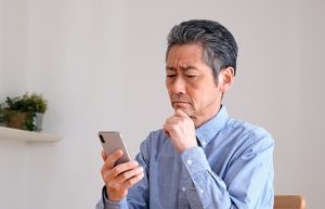 Image of a senior man squinting at his smartphone